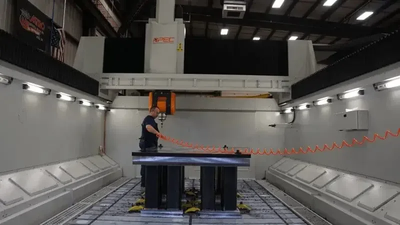 An Astro machinist working at a large 5-axis gantry machining center
